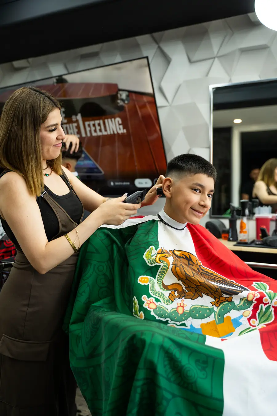 Barber and a smiling kid in the chair at JM Lady Barber